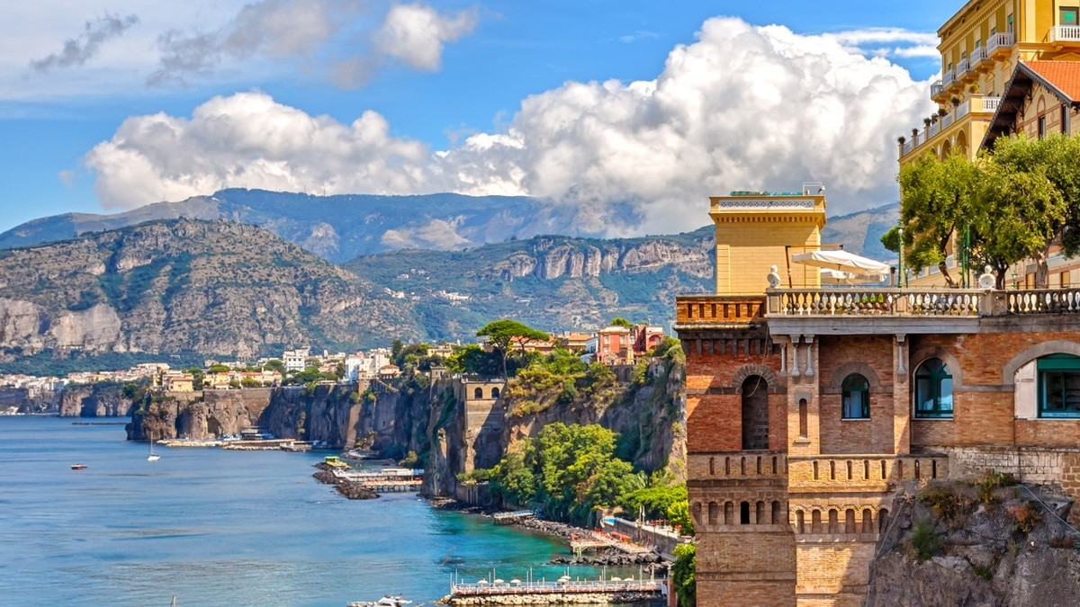 Sorrento coastline with a marina and clifftop buildings under a blue sky