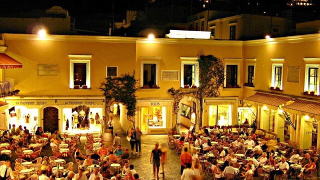 Busy cafes in Capri's Piazzetta beneath the town hall and hillside homes