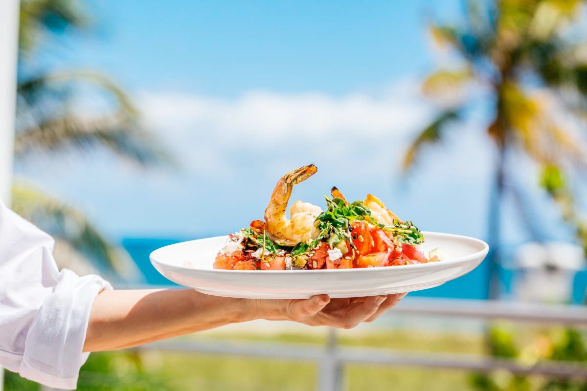 Waiter serving a seafood dish at a restaurant on the coast